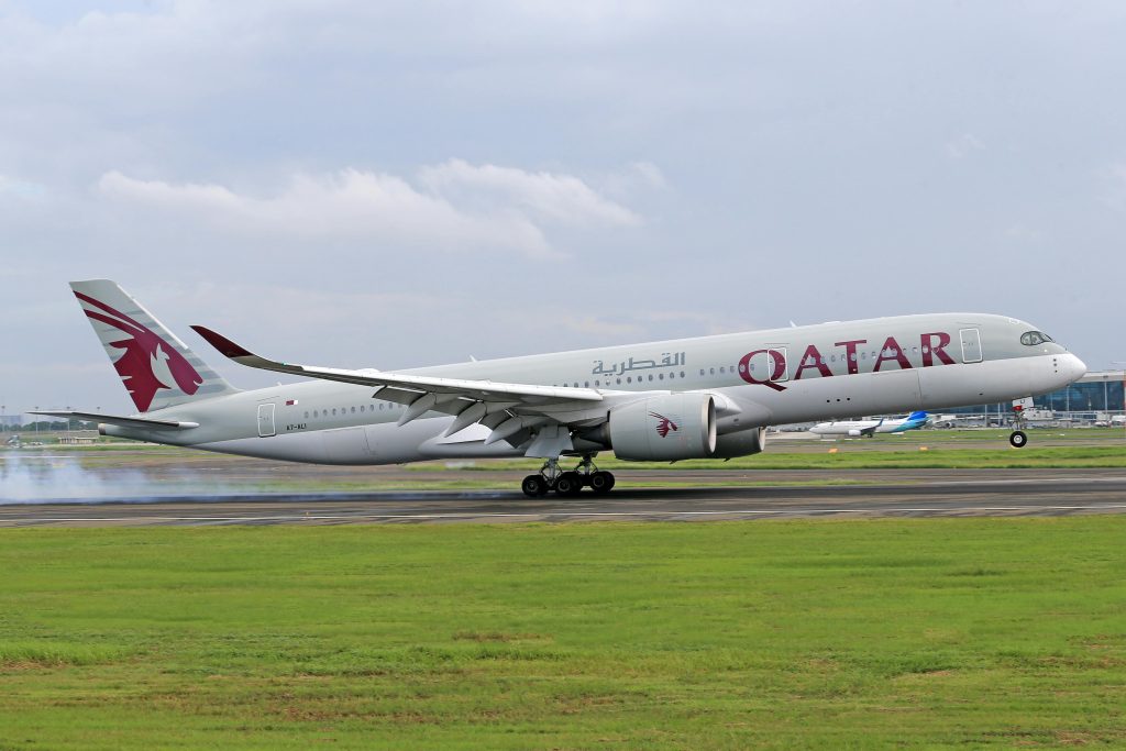 Qatar Airways plane taking off from runway. 