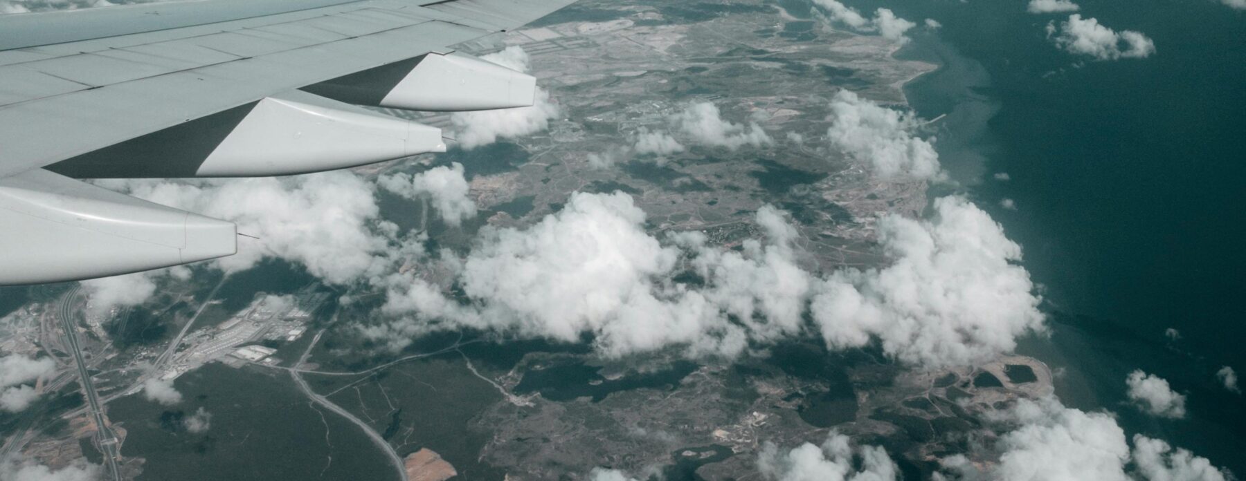 ariel image of a plane wing above the clouds