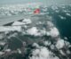 ariel image of a plane wing above the clouds